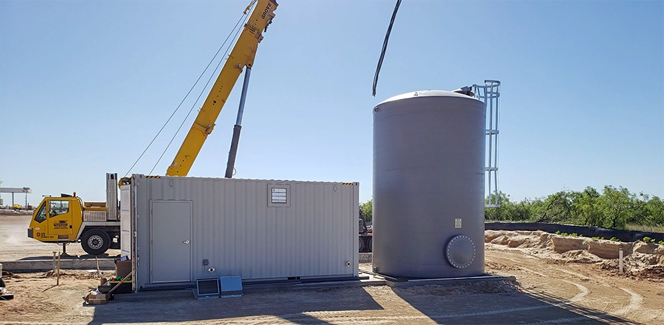 Construction site with crane and water treatment system on bare ground
